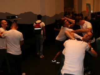 Documentation of a performance featuring a team of &ldquo;coal miners&rdquo; and a team of &ldquo;astronomers,&rdquo; in which members of opposing teams wrestle with their eyes physically pressed against each other