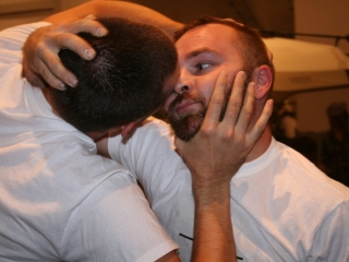 Documentation of a performance featuring a team of &ldquo;coal miners&rdquo; and a team of &ldquo;astronomers,&rdquo; in which members of opposing teams wrestle with their eyes physically pressed against each other