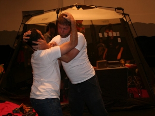 Documentation of a performance featuring a team of &ldquo;coal miners&rdquo; and a team of &ldquo;astronomers,&rdquo; in which members of opposing teams wrestle with their eyes physically pressed against each other