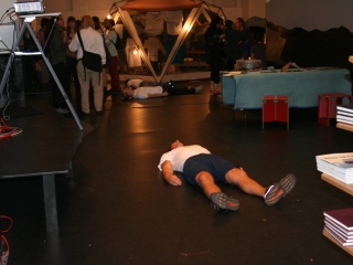 Documentation of a performance featuring a team of &ldquo;coal miners&rdquo; and a team of &ldquo;astronomers,&rdquo; in which members of opposing teams wrestle with their eyes physically pressed against each other