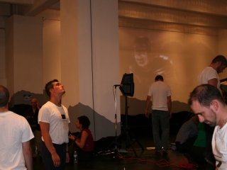Documentation of a performance featuring a team of &ldquo;coal miners&rdquo; and a team of &ldquo;astronomers,&rdquo; in which members of opposing teams wrestle with their eyes physically pressed against each other
