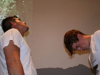 Documentation of a performance featuring a team of &ldquo;coal miners&rdquo; and a team of &ldquo;astronomers,&rdquo; in which members of opposing teams wrestle with their eyes physically pressed against each other