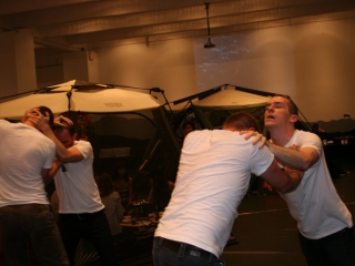 Documentation of a performance featuring a team of &ldquo;coal miners&rdquo; and a team of &ldquo;astronomers,&rdquo; in which members of opposing teams wrestle with their eyes physically pressed against each other