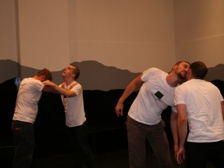 Documentation of a performance featuring a team of &ldquo;coal miners&rdquo; and a team of &ldquo;astronomers,&rdquo; in which members of opposing teams wrestle with their eyes physically pressed against each other